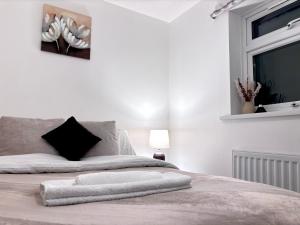 um quarto branco com uma cama e uma janela em Entire House, Sleeps 5, FreeParking, Work&Leisure em Shenley Brook End
