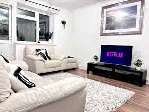 uma sala de estar com um sofá e uma televisão em Entire House, Sleeps 5, FreeParking, Work&Leisure em Shenley Brook End
