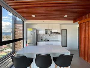 cocina con mesa blanca y sillas negras en Luxury apartment in San José, en San José