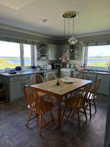 una cucina con tavolo e sedie in legno di Braighe Cottage a Stornoway Altre 23 foto