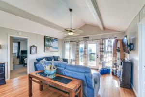 - un salon avec un canapé bleu et une table dans l'établissement Surfside Second Row Beach House with Ramp and Deck, à Surfside Beach