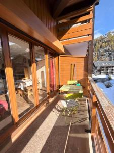 a balcony of a house with a table and chairs at Résidence Les Cordeliers - Studio pour 4 Personnes 171 in Valloire