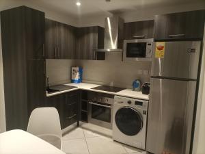 een keuken met een roestvrijstalen koelkast en een vaatwasser bij Luxury Two Bedroom at Embassy Gardens by Morninglife Luxury Apartments in Accra