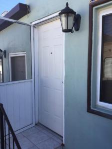 una puerta de garaje blanca con una lámpara en la pared en Almejas A en San Carlos
