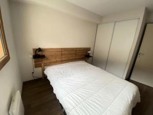a small bedroom with a white bed in it at Résidence Bois De Marie - 5 Pièces pour 8 Personnes 204 in Barèges
