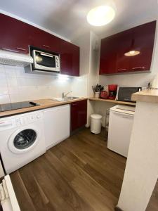 a kitchen with a washing machine and a microwave at Résidence Bois De Marie - 2 Pièces pour 6 Personnes 254 in Barèges