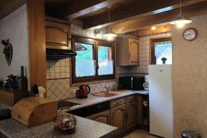 a kitchen with a white refrigerator and a sink at Chalet Cosy - Chalets pour 5 Personnes 111 in Morzine