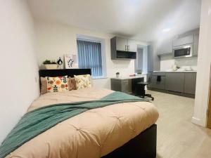 1 Schlafzimmer mit einem großen Bett und einer Küche in der Unterkunft Stretford's Best: Cosy Studio Retreat in Manchester