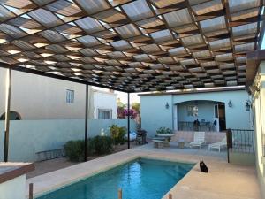 a patio with a swimming pool with a wooden ceiling at Almejas A in San Carlos