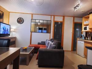 een woonkamer met een bank en een tafel bij Normandie chalet N70 piscine lac golf in Saint-Manvieu-Bocage