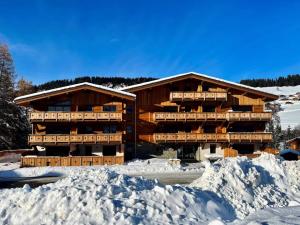 a large building with snow in front of it at Résidence Res Cristal - 3 Pièces pour 4 Personnes 721 in Notre-Dame-de-Bellecombe