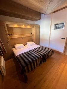Cama grande en habitación con suelo de madera en Résidence L'oree Des Neiges - 4 Pièces pour 6 Personnes 711 en Peisey-Nancroix