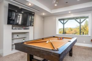 a pool table in a room with a window at TWO homes with Stunning Views King Bed, Level 2 Electric Vehicle Smart Station, Hot Tub, Games and Fire pit, Perfect for Multi-Family Getaways in Coarsegold