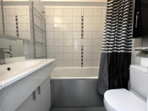 bagno con vasca, lavandino e servizi igienici di Résidence Grande Masse - Studio pour 3 Personnes 911 a Les Menuires