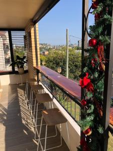 a balcony with chairs and a christmas tree on it at Best Value With City View Sleeps 7 in Brisbane