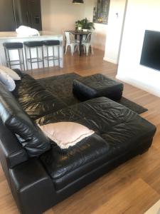 um sofá de couro preto sentado numa sala de estar em Best Value With City View Sleeps 7 em Brisbane