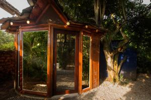 Habitación de madera con espejo frente a un árbol en ITCHIMBIA GARDEN AYAMPE Montaña y Mar, en Ayampe