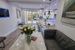 uma sala de estar com um vaso de flores sobre uma mesa em Northbourne House em Longham