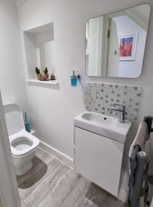 a white bathroom with a toilet and a sink at Northbourne House in Longham