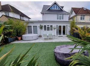 a house with a large backyard with a large lawn at Northbourne House in Longham