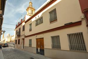 un edificio in una strada con una torre dell'orologio di Charming Apartment at San Bernardo Neighborhood By OUI Sevilla a Siviglia