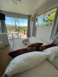 a bedroom with two beds and a large window at LAS ONDAS in Garopaba