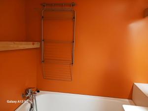 a bathroom with an orange wall with a shower at Résidence Grand Arbois - Studio pour 2 Personnes 051 in Arc 1800
