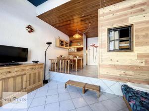 un soggiorno con TV e pareti in legno di Résidence Agena - STUDIO CABINE 4 PERSONNES SUR FRONT DE NEIGE MAE-9061 a Villarembert