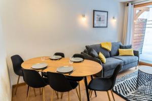 un soggiorno con tavolo e divano di Résidence Le Parc Des Airelles - 2 Pièces pour 6 Personnes 301 a Les Orres