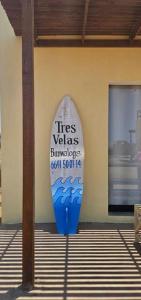a surfboard sign on the side of a building at Tres Velas Surf in Celestino Gasca