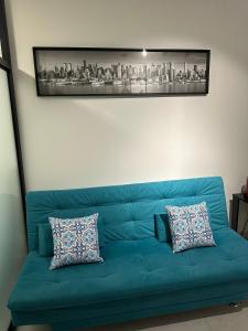 a blue couch with two pillows in a living room at LOFTS CARIJOS CENTRO BH in Belo Horizonte