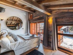 een slaapkamer met een bed en een groot raam bij Résidence Ksar A - 5 Pièces pour 8 Personnes 301 in Megève