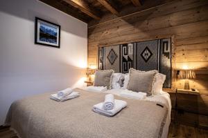 een slaapkamer met een bed met handdoeken erop bij Résidence Nanook - Chalets pour 10 Personnes 931 in Morzine