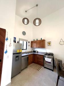 una cocina con electrodomésticos de acero inoxidable y armarios de madera en Casa Ola, en Playa Venao