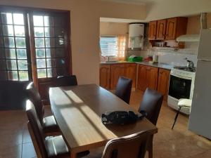 a kitchen with a wooden table with chairs and a tableasteryasteryasteryasteryastery at ELINOR-CASA PLAYERA in Santa Clara del Mar