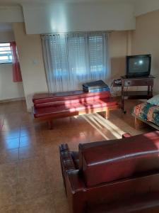 ein Wohnzimmer mit Sofa und Fernseher in der Unterkunft ELINOR-CASA PLAYERA in Santa Clara del Mar