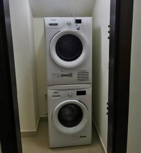 a washing machine and a dryer in a room at Al Andulcia Airport Road Complex مجمع الاندلسية طريق المطار 