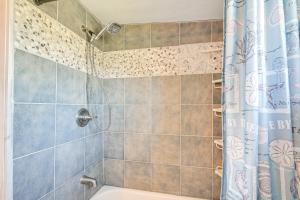 a bathroom with a shower with a white tub at 1 Mi to Surfside Beach BBQ-Ready Home in Freeport in Freeport +19 photos