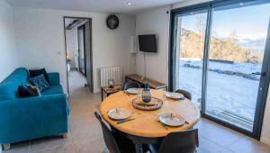 a table and chairs in a living room with a large window at Résidence Pramouton - Un logement tout confort au cœur d’un chalet MAE-0411 in Le Mélézet