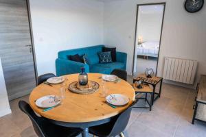 a dining room table with chairs and a blue couch at Résidence Pramouton - Un logement tout confort au cœur d’un chalet MAE-0411 in Le Mélézet +2 photos