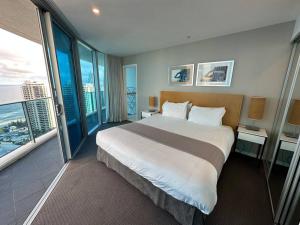 a bedroom with a large bed and a large window at Hilton Surfers High Floor Beach Views in Gold Coast