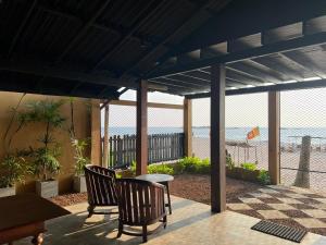 d'une terrasse avec 2 chaises et une table et vue sur la plage. dans l'établissement The Oceanfront Residence, à Ambalangoda