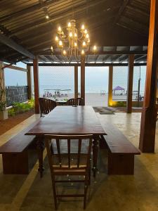 une grande table en bois avec des chaises et un lustre dans l'établissement The Oceanfront Residence, à Ambalangoda