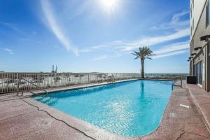 a swimming pool with a palm tree next to a building at Royal Palms 907 in Gulf Shores +27 photos