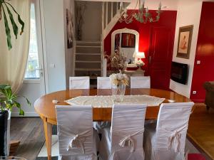 a dining room with a table and white chairs at Chez Patou in Laval