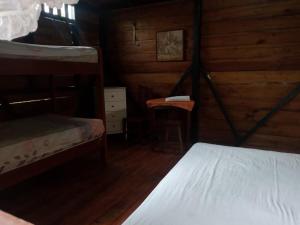 a bedroom with two bunk beds and a stool at Hostal TÉ de Menta in Muisne