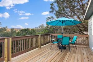 une terrasse avec une table, des chaises et un parasol dans l'établissement The Bluebonnet Bungalow in Canyon Lake near Comal Park!, à Canyon Lake