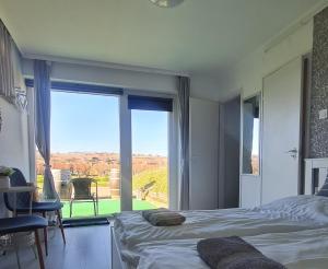 a bedroom with a bed and a large window at Lugas Apartman in Villány