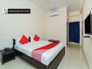a bedroom with a large bed with red pillows at Super Collection O Jagadamba Near Beach Road in Visakhapatnam