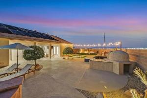 un patio con sofá y sombrilla en HotTub, Pool, Waterfall, RV parking 5BR Lux Home en Las Vegas